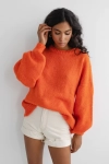 pomarańczowy sweter damski z bufiastym rękawem.webp